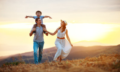 Happy family father of mother and child son  on nature at sunset