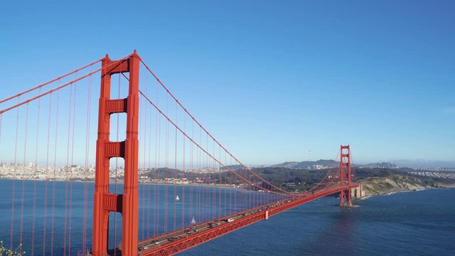 back view of young beautiful asian hiker traveler standing on mountain peak with backpack sightseeing Golden Gate Bridge San Francisco California USA. famous tourism attraction nature blue sky ocean