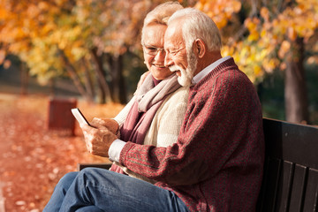 Couple in autumn park with tablet in hands