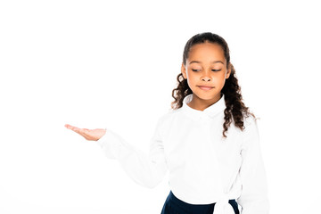 sceptical african american schoolgirl pointing with hand isolated on white