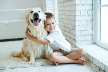 A child with a dog. Beautiful boy at home with a dog. 