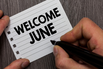 Conceptual hand writing showing Welcome June. Business photo showcasing Calendar Sixth Month Second Quarter Thirty days Greetings Man holding marker notebook page Wooden background