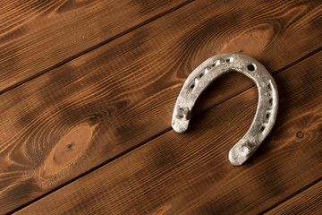 Silver horseshoe on a wooden table. An old horseshoe.