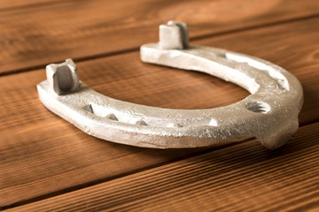 Silver horseshoe on a wooden table. An old horseshoe. Close up.