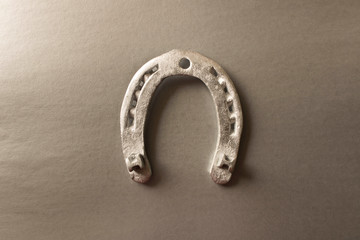 Silver horseshoe on a gray background. An old horseshoe. Close up.
