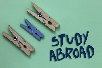 Conceptual hand writing showing Study Abroad. Business photo showcasing Pursuing educational opportunities in a foreign country Three brown blue vintage clear background Holding things