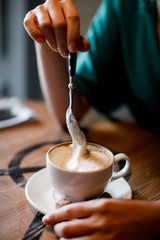 Closeup of hand with coffee cup in a cafe 