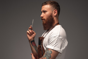 Serious bearded stylist with scissors