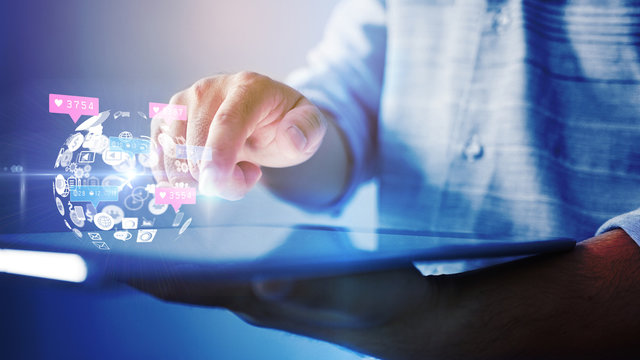 Hand using tablet with social media icons