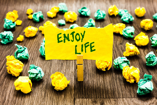 Writing note showing Enjoy Life. Business photo showcasing Any thing, place,food or person, that makes you relax and happy Clothespin holding yellow note paper crumpled papers several tries