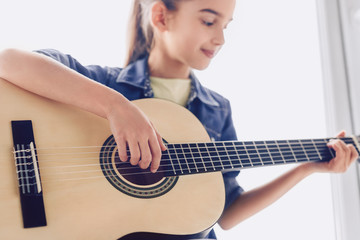 Girl learning to play guitar