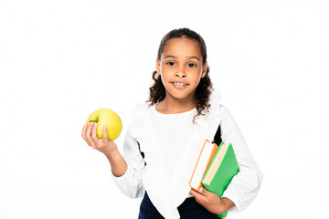 adorable african american schoolgirls looking at camera while holding books and apple isolated on white