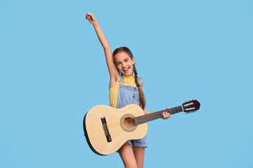 Cheerful girl playing guitar