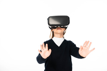 schoolgirl standing with outstretched hands while using virtual reality headset isolated on white