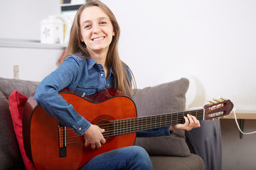 Fototapeta premium woman play guitar at home