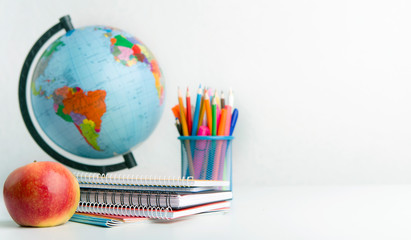 Naklejka premium World globe, apple and supplies on white background