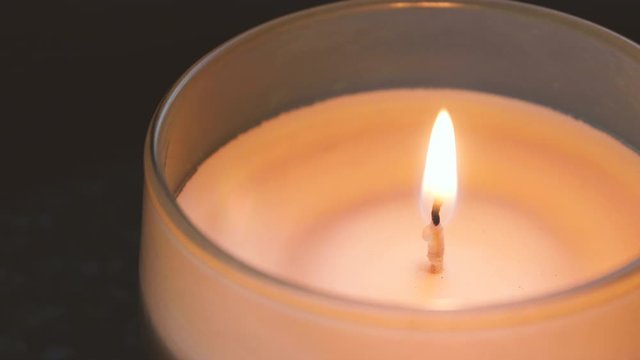 Candle burns in glass jar, close-up. Fire and homeliness