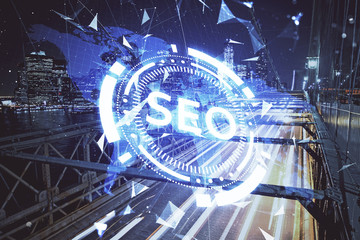 SEO hologram on city view with skyscrapers background double exposure. Search optimization concept.