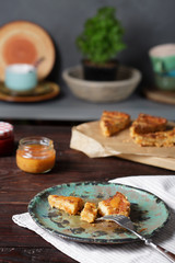 Fototapeta na wymiar Cheddar shortbread cheesecake, cheddar pie and peach sauce on wooden table.