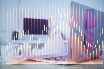 Stock market chart hologram drawn on personal computer background. Double exposure. Concept of investment.