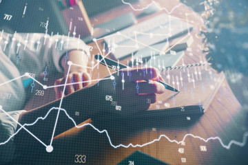 Financial forex charts displayed on woman's hand taking notes background. Concept of research. Double exposure