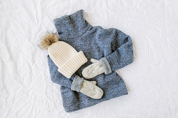 Blue sweater with  hat. Autumn/winter fashion clothes collage on white background. Top view flat lay.