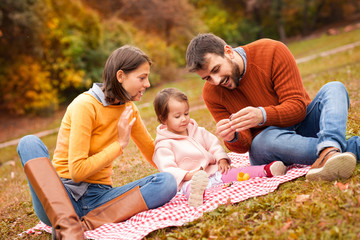 Family picnicking outdoor with their cute daughter