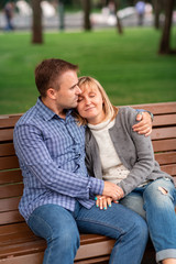 Happy young couple hugging and laughing together in the park