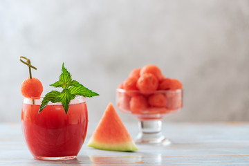 Watermelon drink in glass and watermelon balls. A refreshing summer cocktail