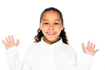 cheerful african american schoolgirl gesturing and smiling at camera isolated on white