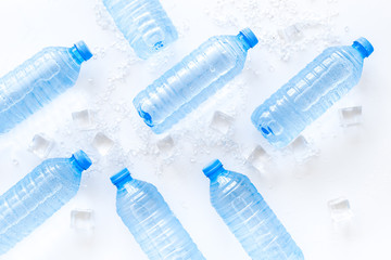 empty plastic bottles for pure water with ice cubes on white background top view pattern