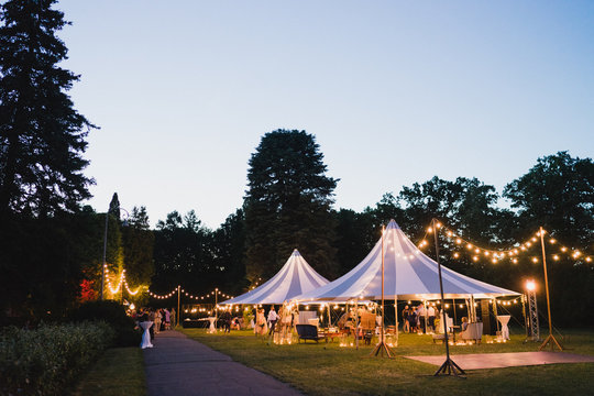 Coziness and style. Modern event design. Lounge zone and wedding reception decorations outdoors in the evening.