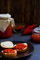 ajvar, appetizer of baked peppers on the table, bread with ajvar, toast with ajvar, balkan appetizer of baked peppers, vertical, space for your text