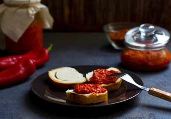 ajvar, appetizer of baked peppers on the table, bread with ajvar, toast with ajvar, balkan appetizer of baked peppers, vertical, space for your text