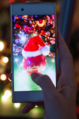 Online Christmas greetings. man photographs a beautiful red apple in santa hat