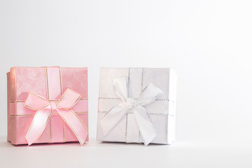 Two decorative holiday gift boxes with ribbon bow for congratulations, surprise, white and pink presentations on a white background with copy space