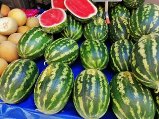 Watermelons on a bench for sale.