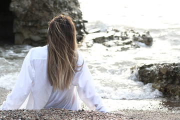 young woman on the beach in white shirt