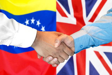 Handshake on Venezuela and UK flag background.