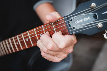 Fmaj7 chord - close-up male Caucasian hand takes a chord on a 6 string guitar