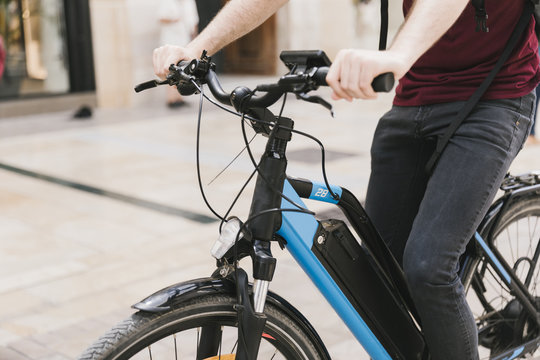 Cyclist riding e-bike through city