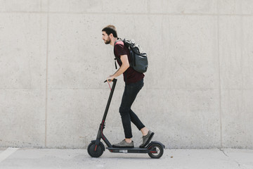 Sideways man riding e-scooter