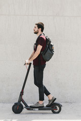 Medium shot man riding e-scooter on street