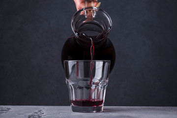 Close up  hand pouring fruit  drink  in a glass.