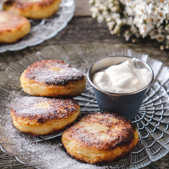 Cottage cheese pancakes with sour cream.  Closeup