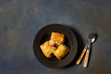 Sarma - traditional dish of Balkan cuisine. Cabbage rolls with meat and rice. Balkan cuisine. Serbian cuisine. Dark background. Top view. Space for text