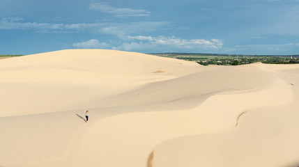 Female silhouette walking in desert sand dunes of Mui Ne, Vietnam