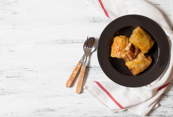 Sarma - traditional dish of Balkan cuisine. Cabbage rolls with meat and rice. Balkan cuisine. Serbian cuisine. Light wooden background. Top view. Space for text
