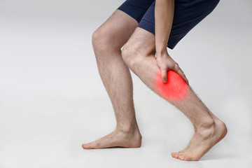 Man with injured calf, massaging painful leg muscle
