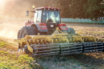 tractor cultivator plows the land, prepares for crops. dust on field